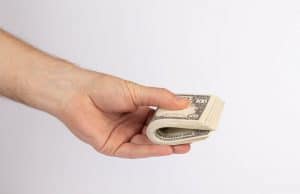 Hand holding stack of dollar bills